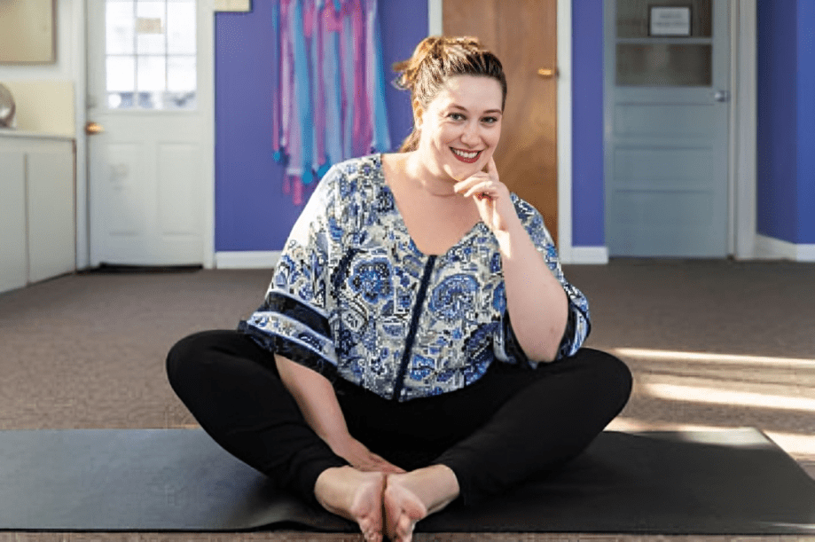 Relaxed woman sitting on yoga mat
