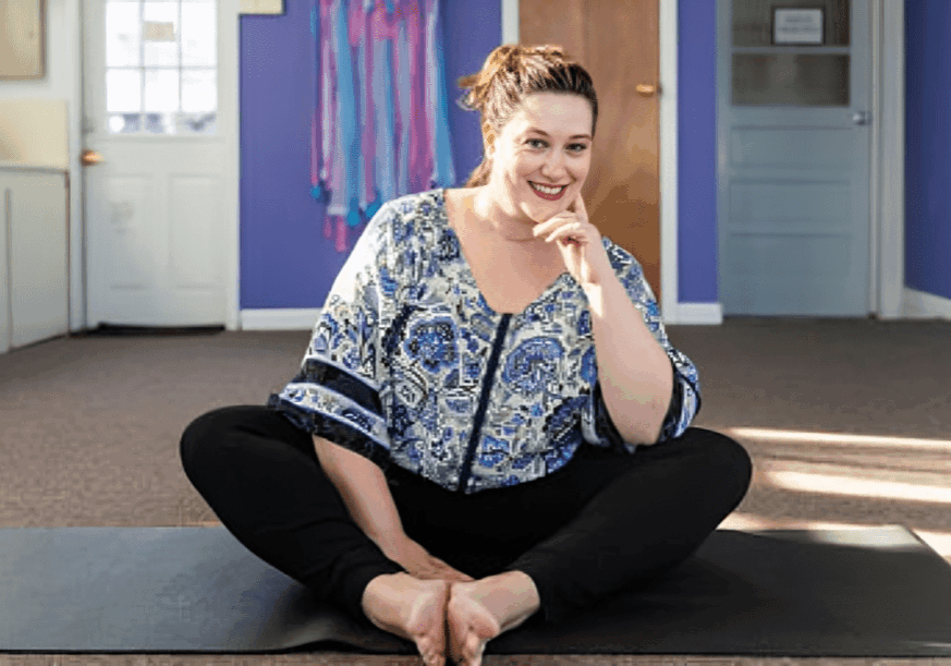 Relaxed woman sitting on yoga mat
